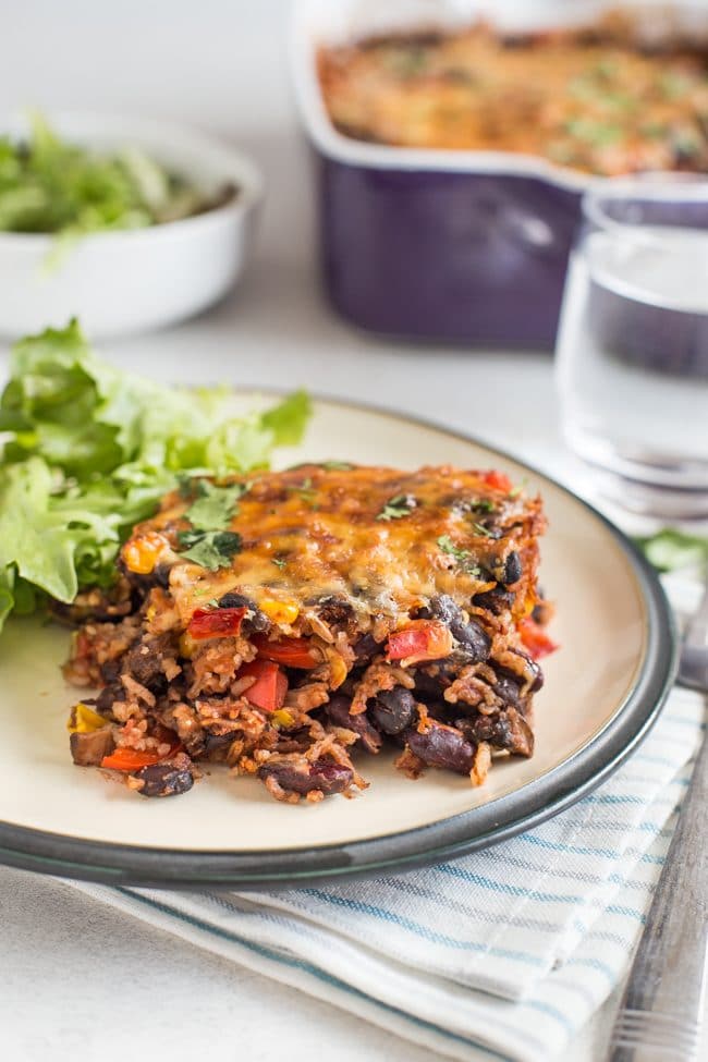 A portion of vegetarian chilli and rice bake on a plate with salad