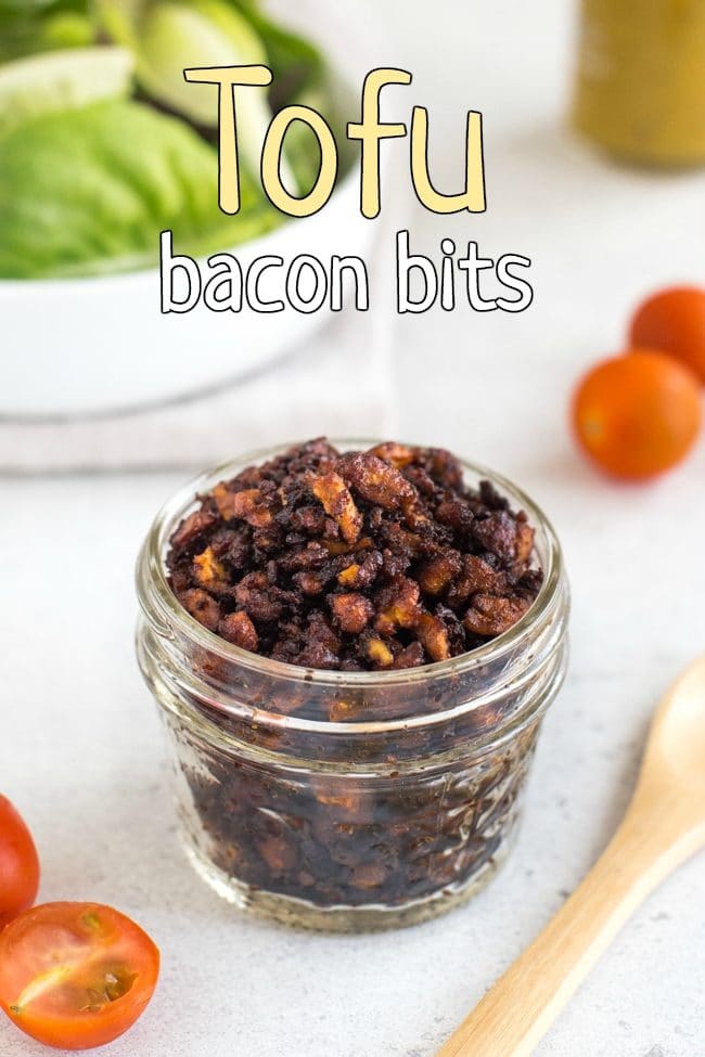 Homemade tofu bacon bits in a glass jar with salad and tomatoes