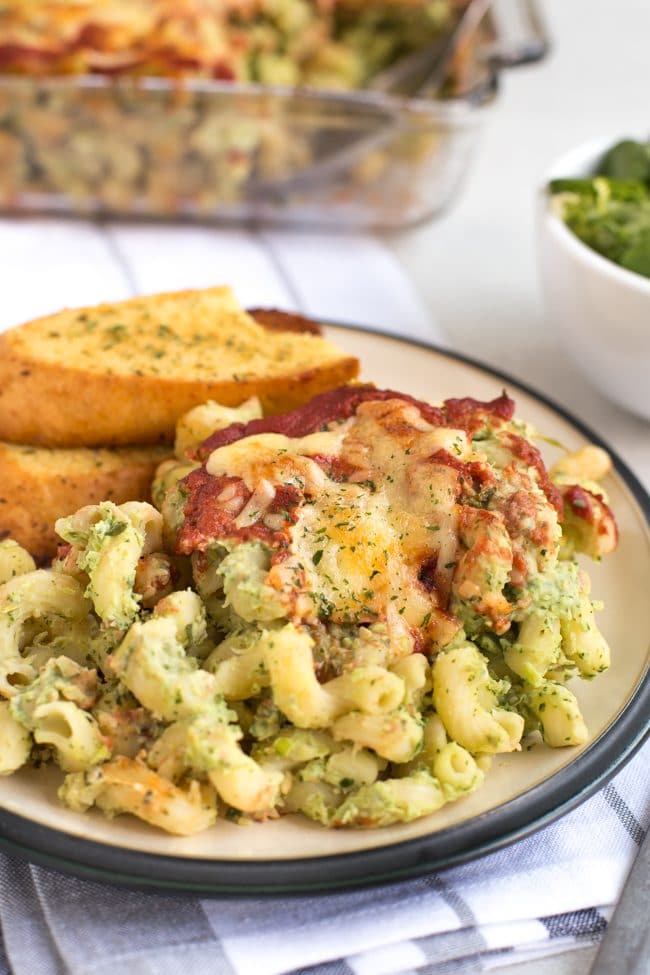 Portion of creamy pasta bake on a plate with garlic bread