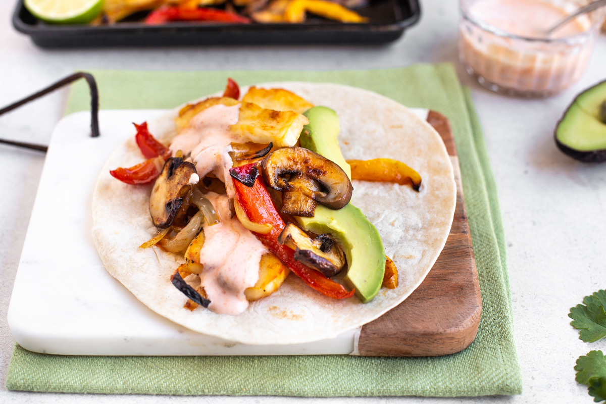 A small flour tortilla topped with roasted vegetables, halloumi cheese and avocado.