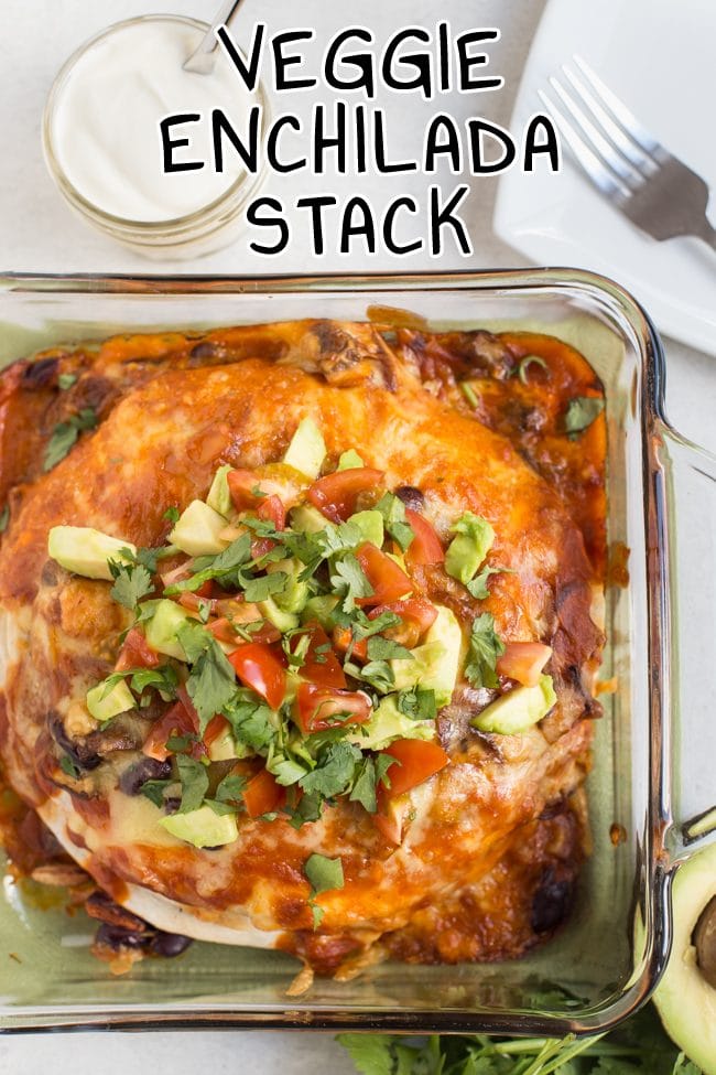 Veggie enchilada stack topped with avocado and tomatoes, shot from above