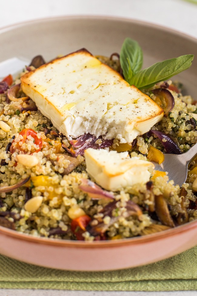 Slice of roasted feta with a scoop removed, on top of roasted vegetable quinoa