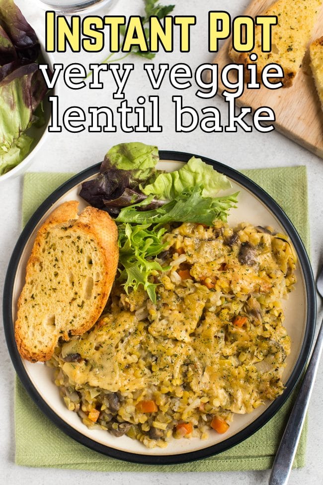 Portion of Instant Pot lentil bake on a plate with garlic bread and salad