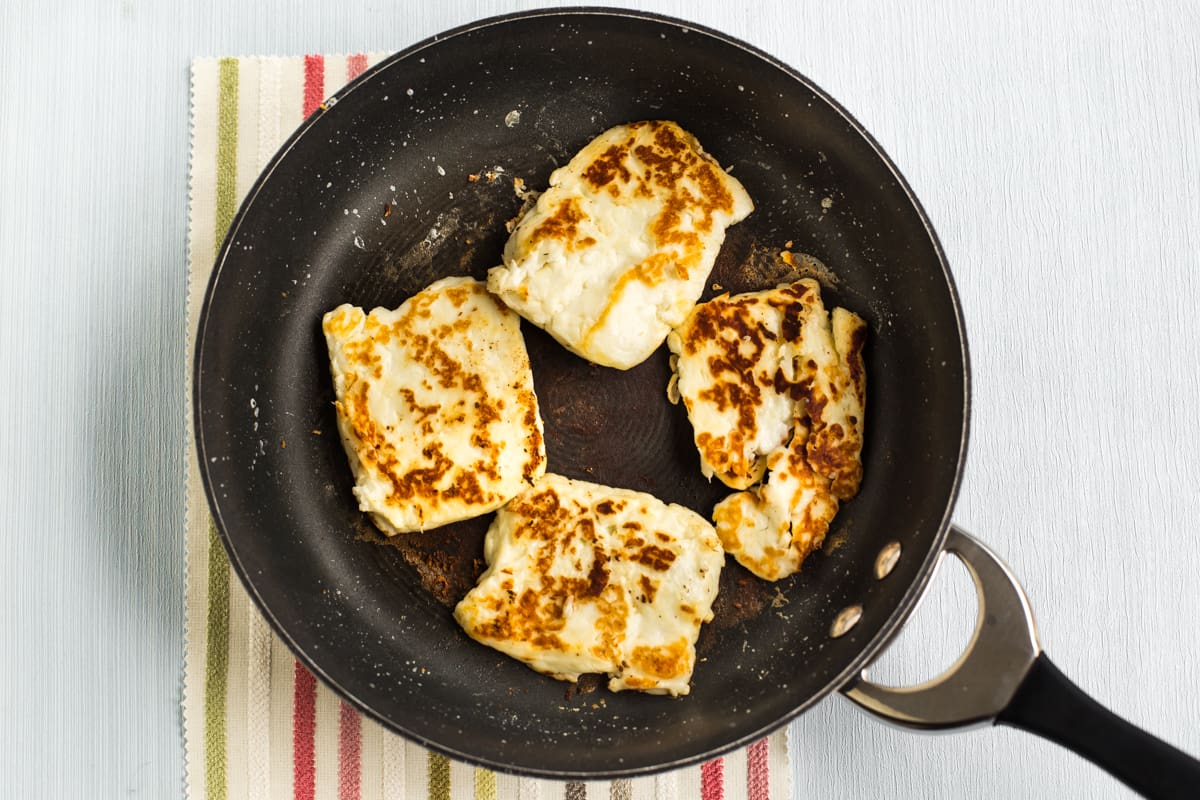 Crispy halloumi cheese cooking in a frying pan