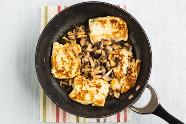 Halloumi cheese and garlic mushrooms cooking in a frying pan