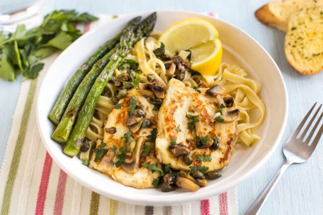 Portion of halloumi piccata served with tagliatelle and asparagus