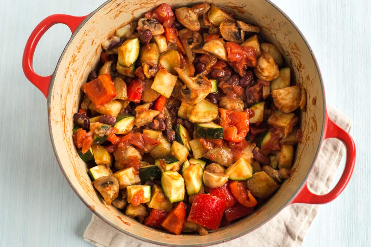 Potatoes and vegetables in tomato sauce in a large casserole dish.