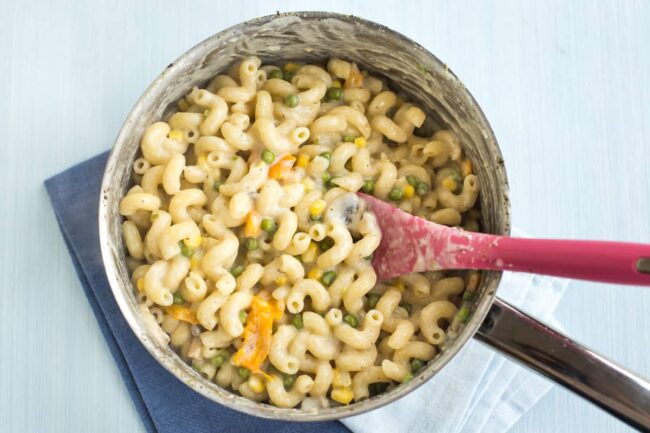 Creamy vegetable pasta cooked in a saucepan.