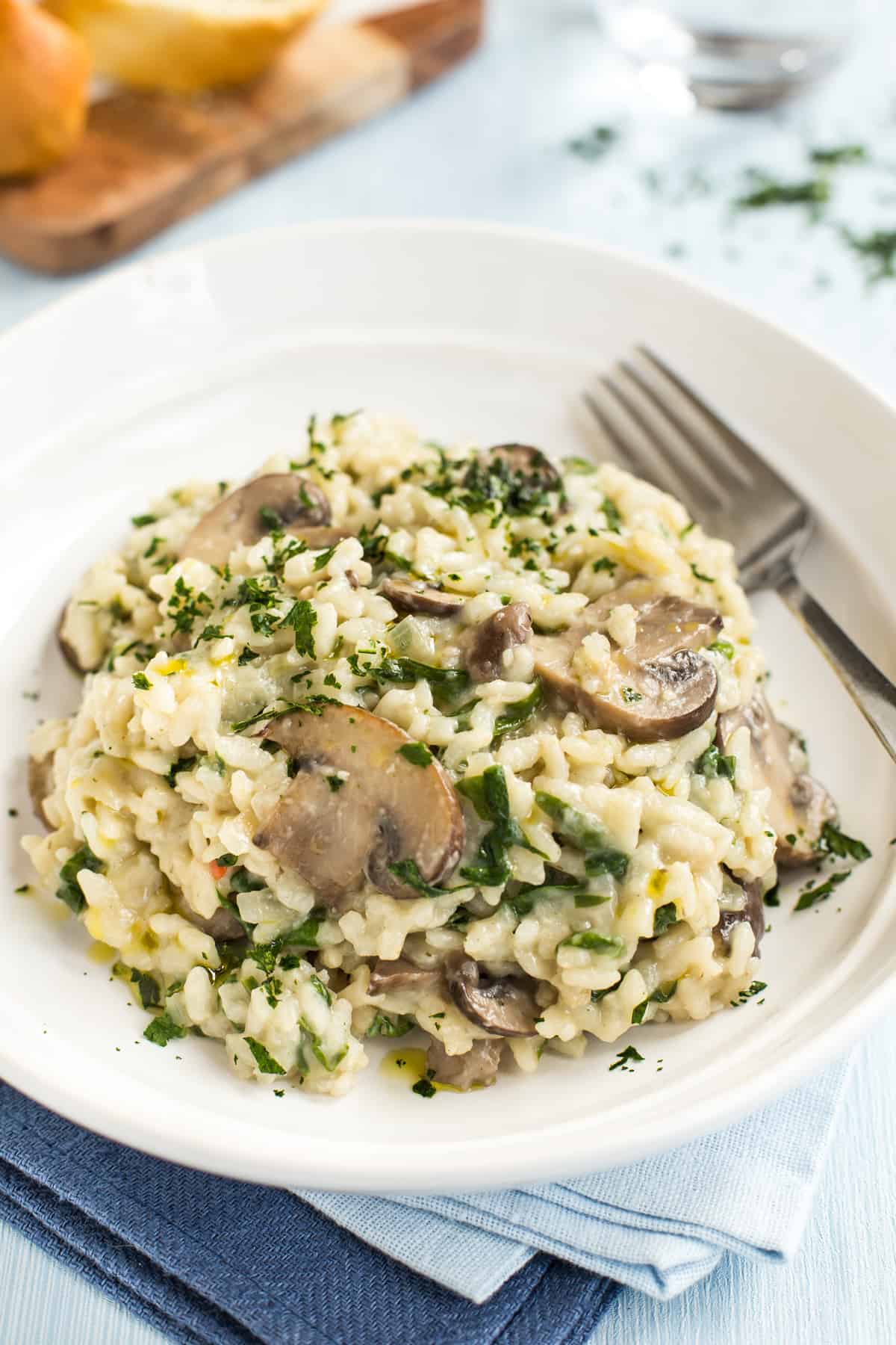 Portion of mushroom and spinach risotto in a bowl with a fork.