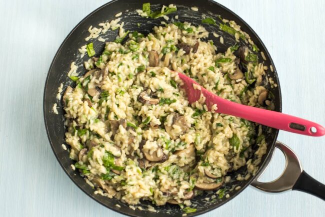 Homemade mushroom and spinach risotto in a wok.