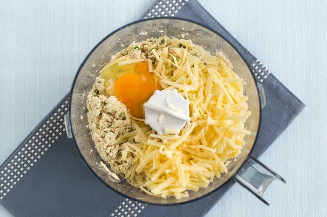 Tofu mixture in a food processor with added egg and grated cheese