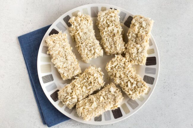 Uncooked breaded tofu on a plate.