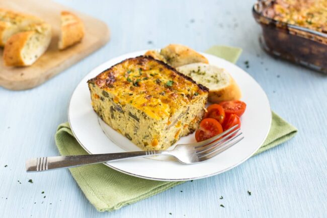 Cheesy lentil and veggie slice on a plate.