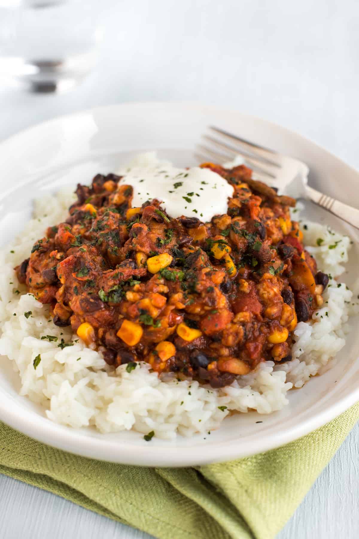 Black bean chilli with rice and sour cream in a bowl.
