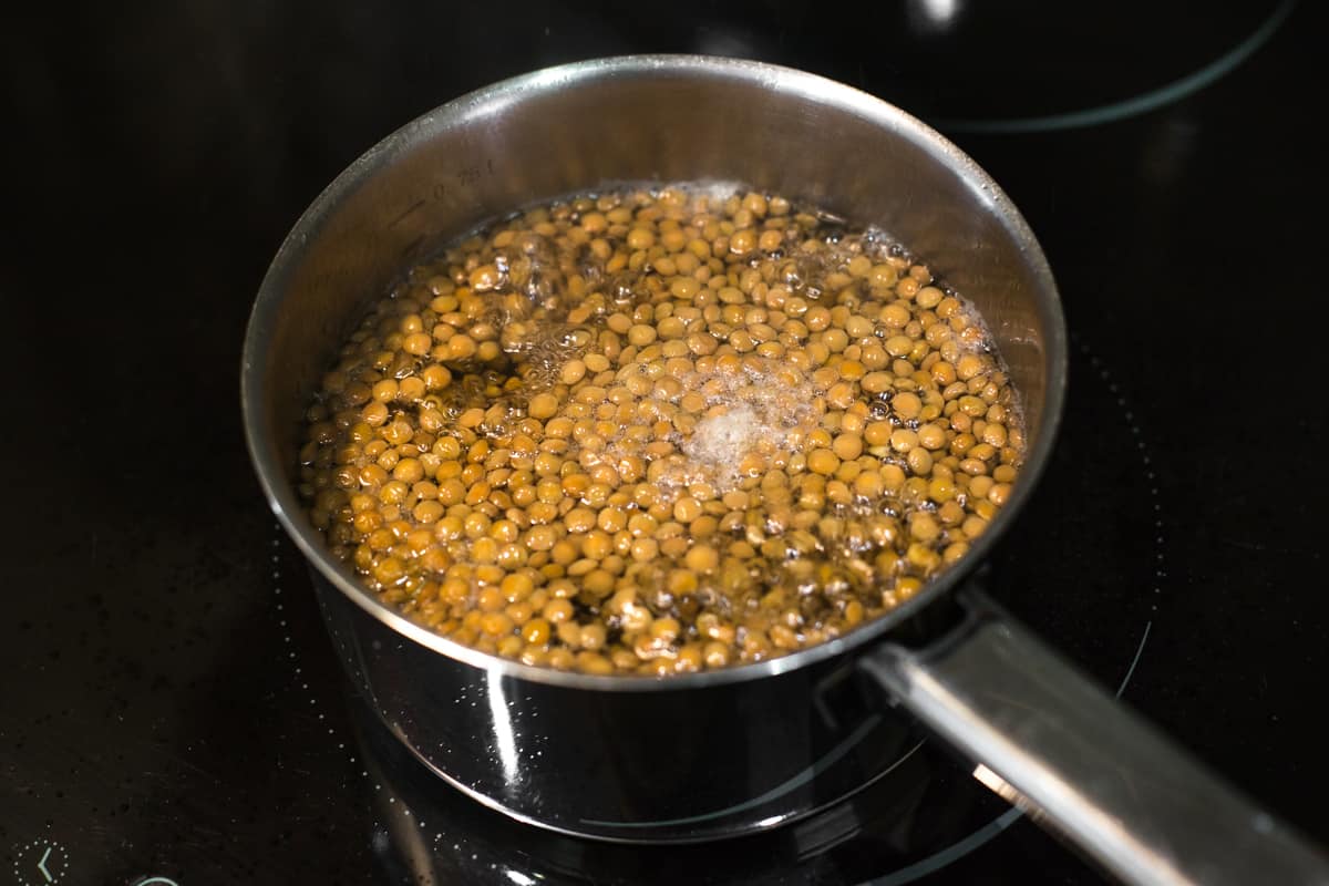 Brown lentils boiling in a saucepan in plenty of water.