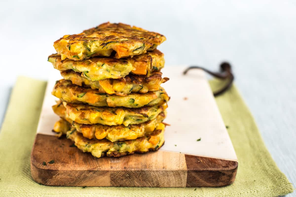 A stack of vegetable fritters on a board.