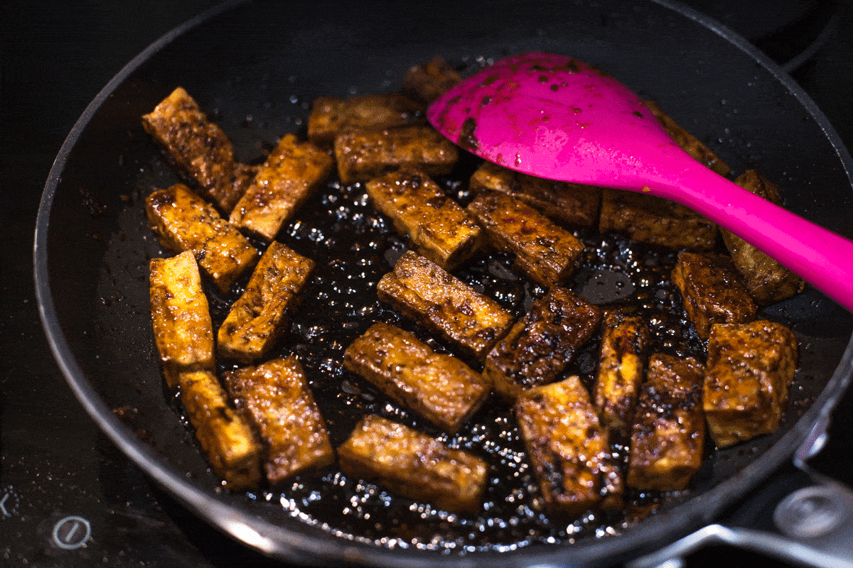 GIF showing tofu cooking in a sticky, bubbling teriyaki sauce.