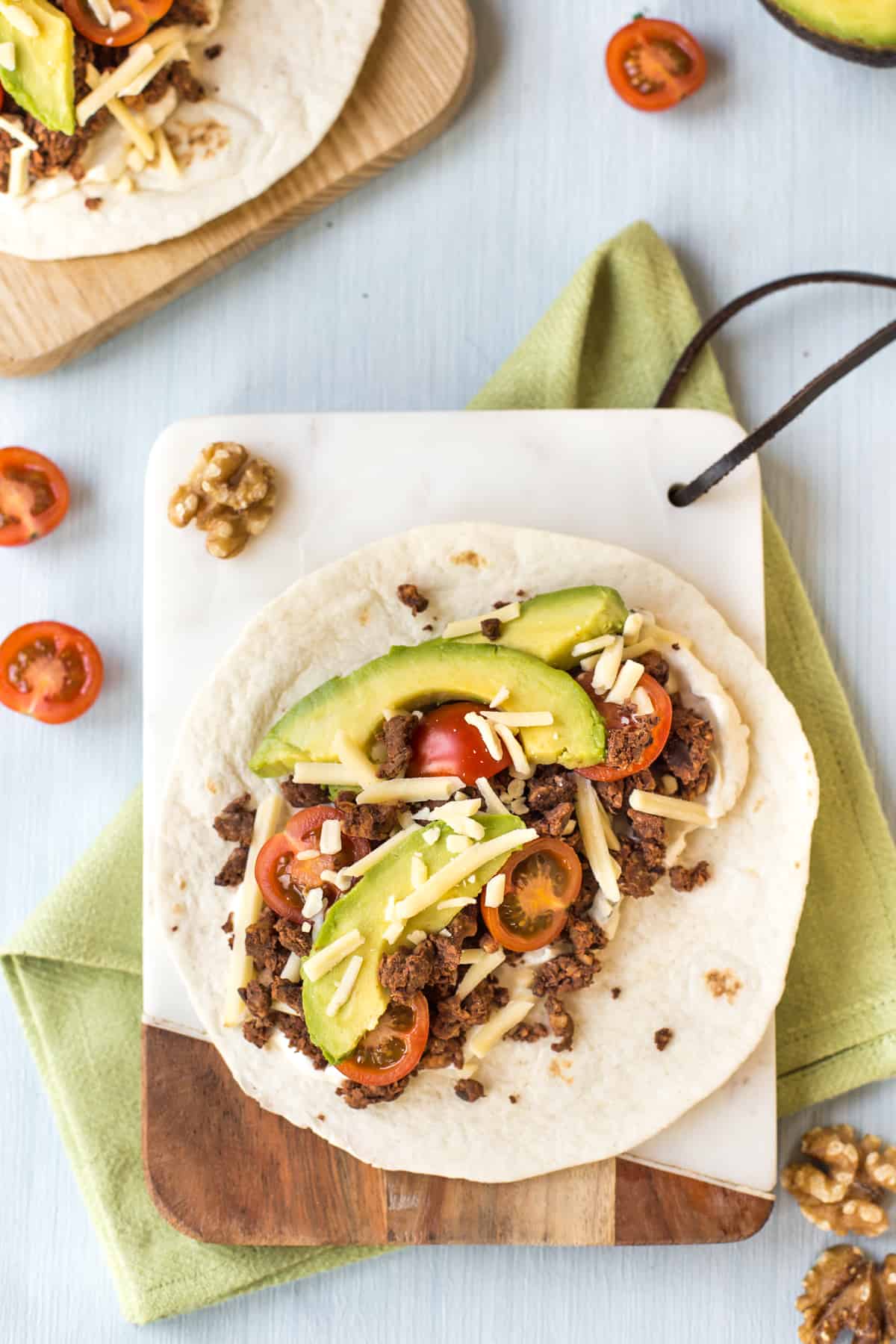 A vegetarian black bean taco topped with avocado and tomatoes.