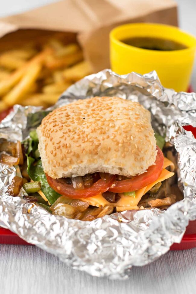 A homemade Five Guys cheese veggie sandwich in partially unwrapped foil.