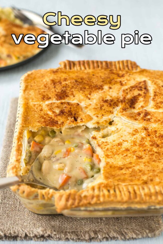 A cheesy vegetable pie with a big scoop being taken.
