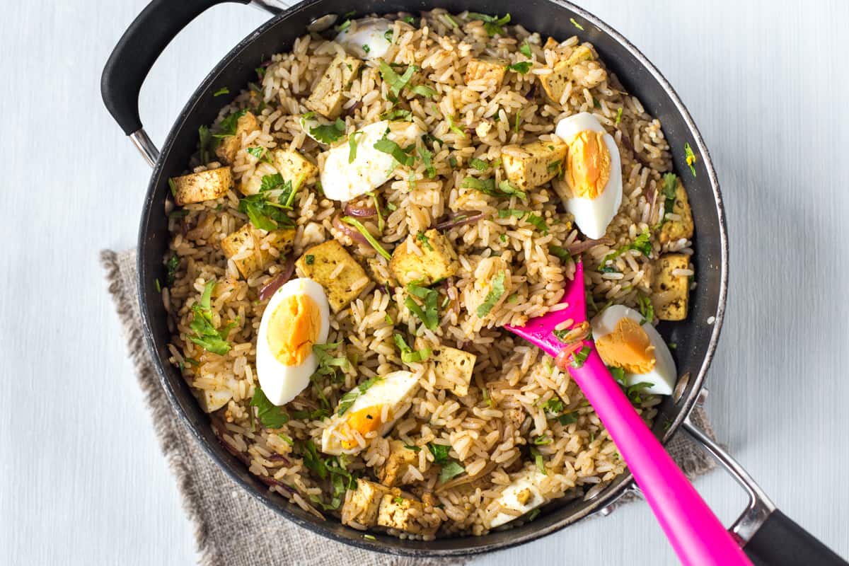 Vegetarian kedgeree in a pan with boiled eggs and tofu.