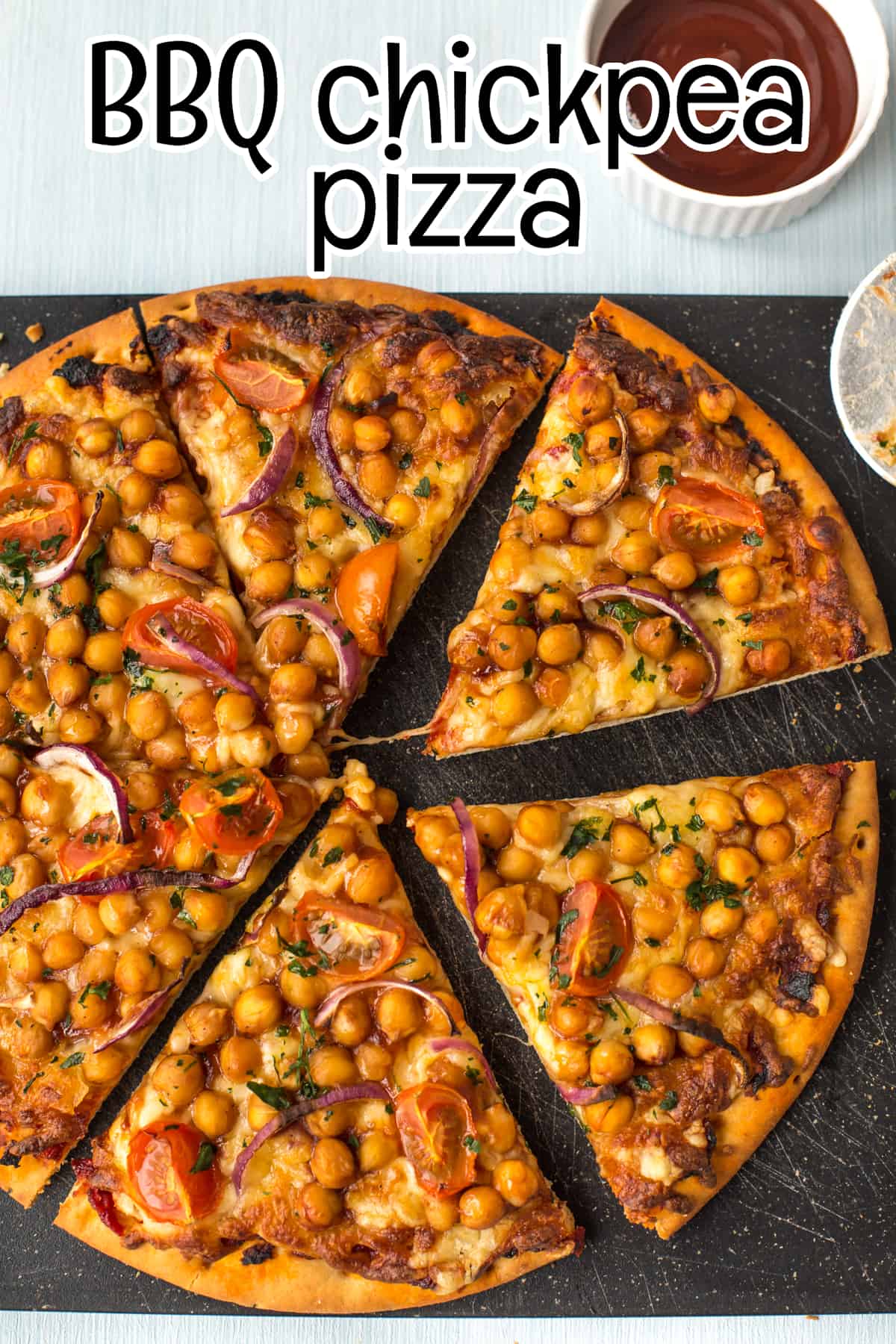A BBQ chickpea pizza cut into slices, shot from above.