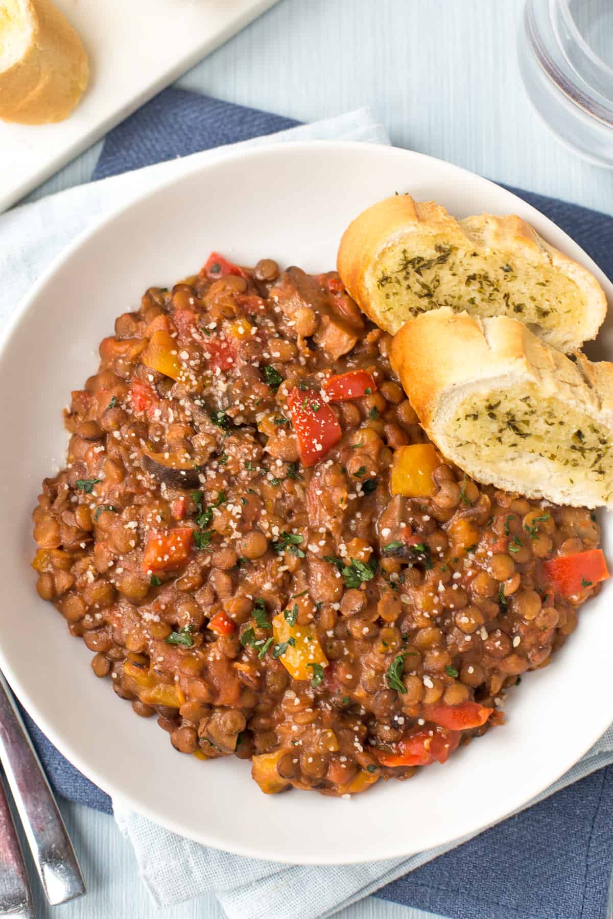 A portion of cheesy lentils with garlic bread.