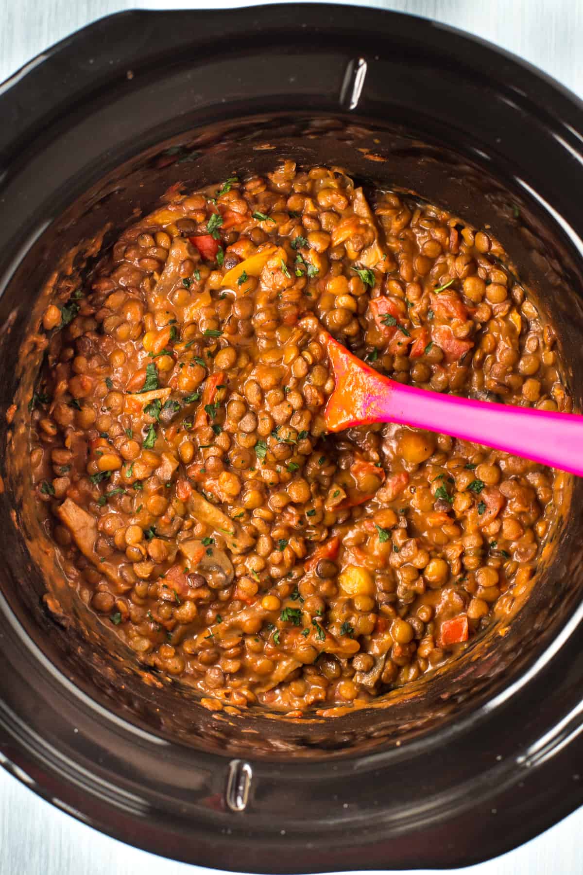 Cheesy lentils and vegetables in a slow cooker pot.