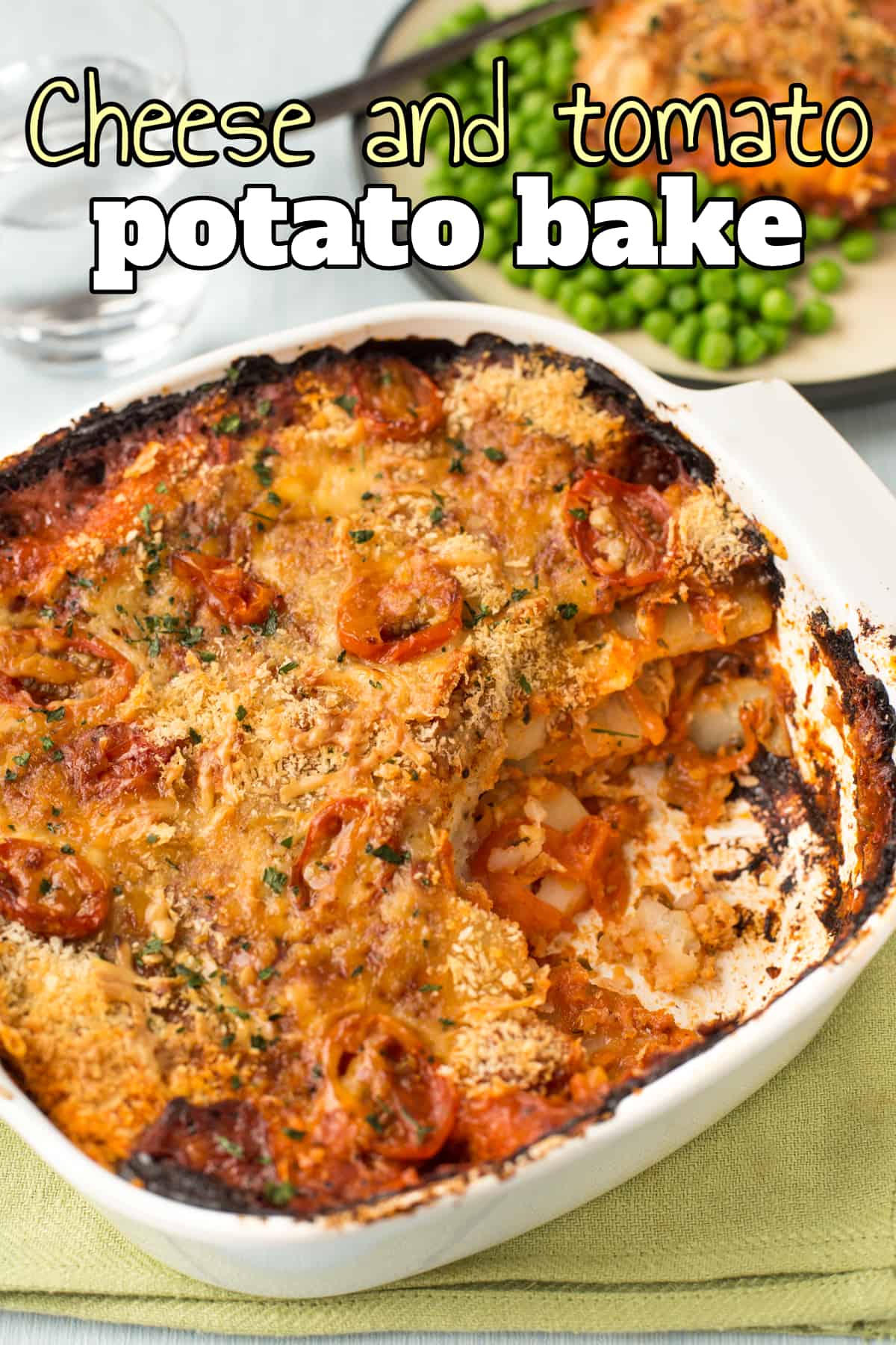 A cheese and tomato potato bake in a baking dish with a scoop removed.