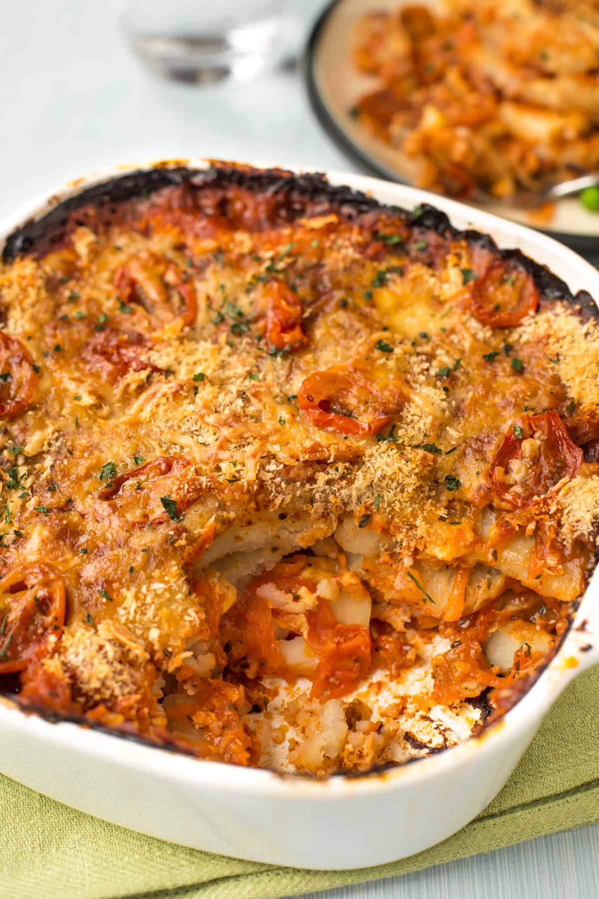 Cheese and tomato potato bake in a dish with a crispy topping.