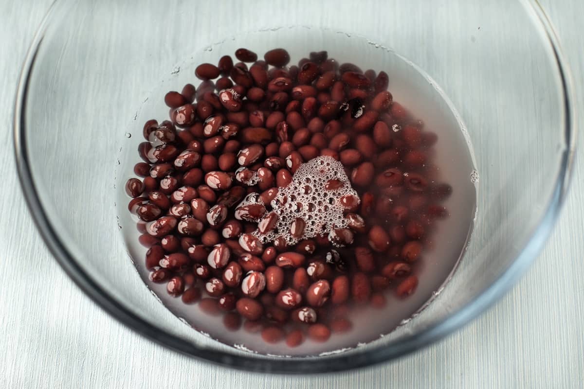 Tinned black beans in a glass bowl with water.