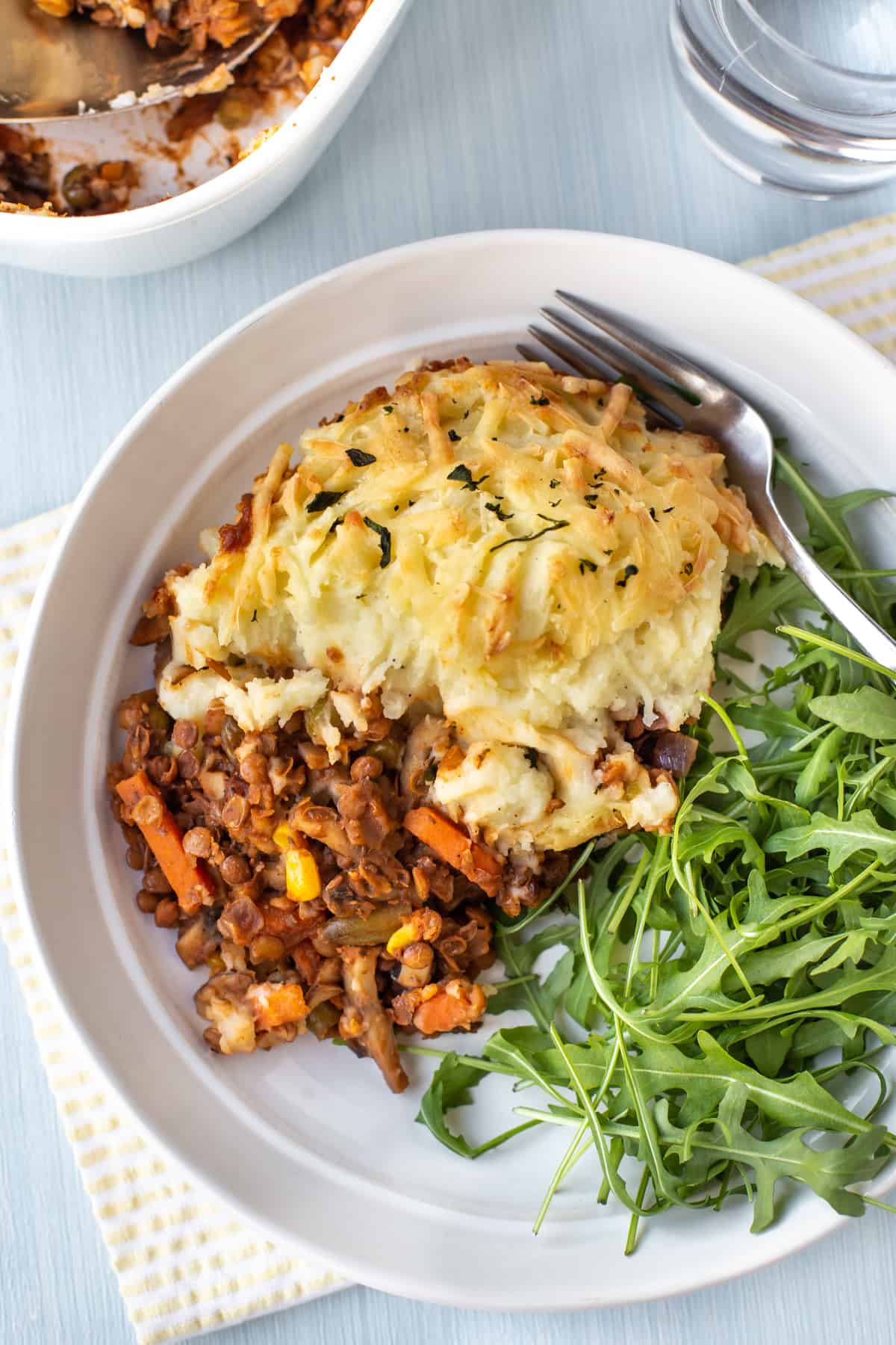 Aerial shot of a portion of shepherd's pie on a plate with fresh rocket.