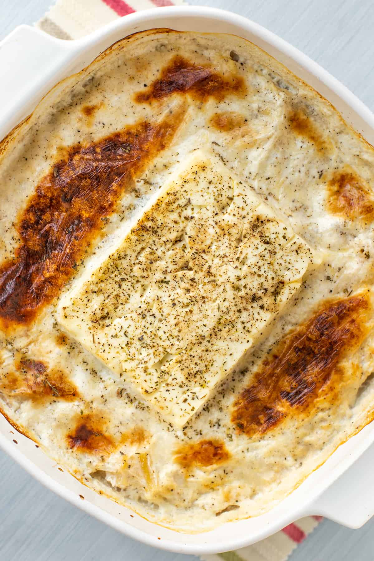 Mac and cheese in a baking dish with a block of crispy baked feta in the middle.