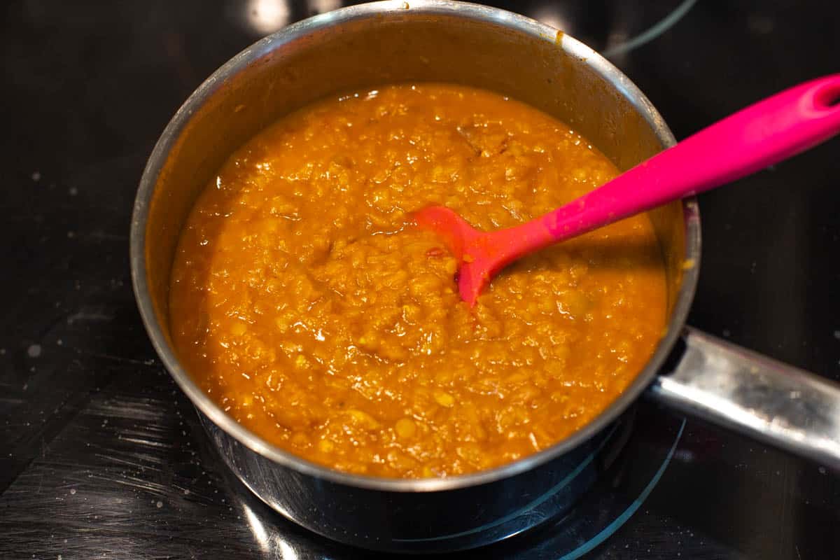 Soft cooked lentils in a saucepan.