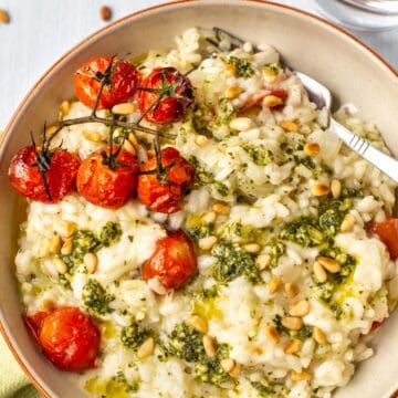 Caprese risotto topped with roasted tomatoes and pesto.