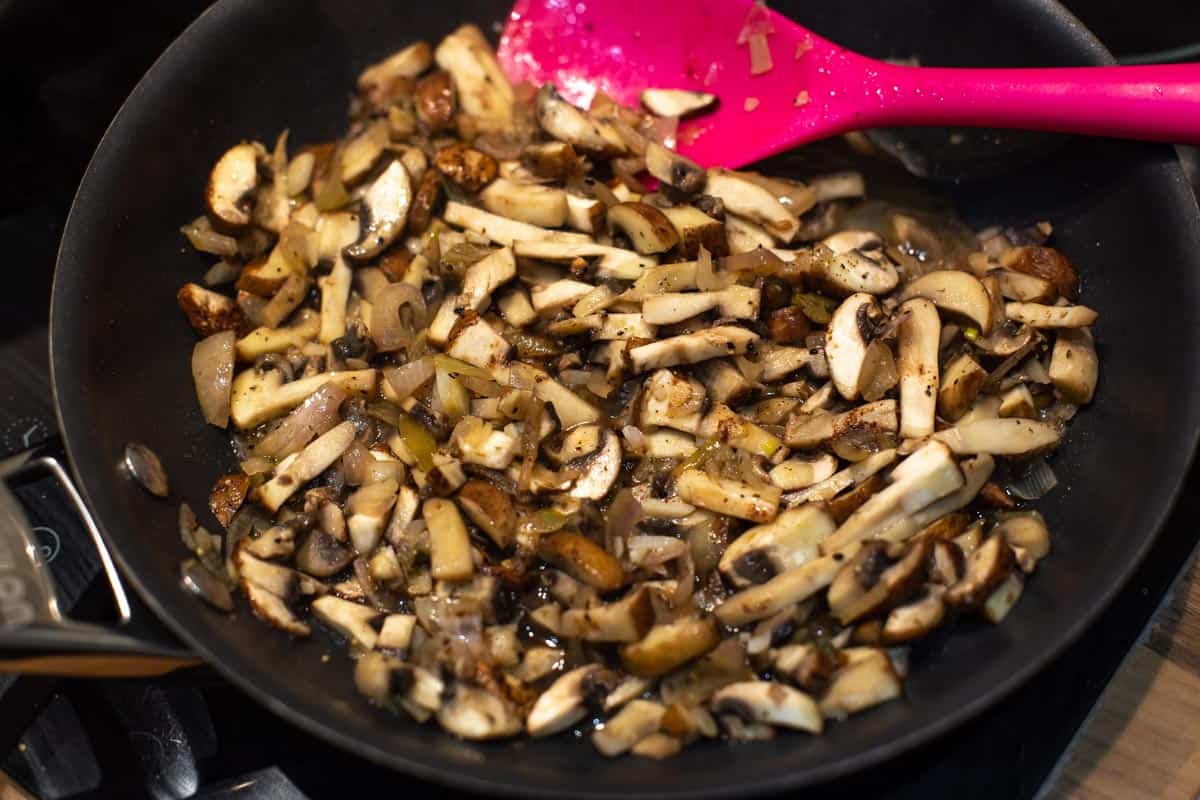 Mushrooms cooked with garlic and shallots in a frying pan.