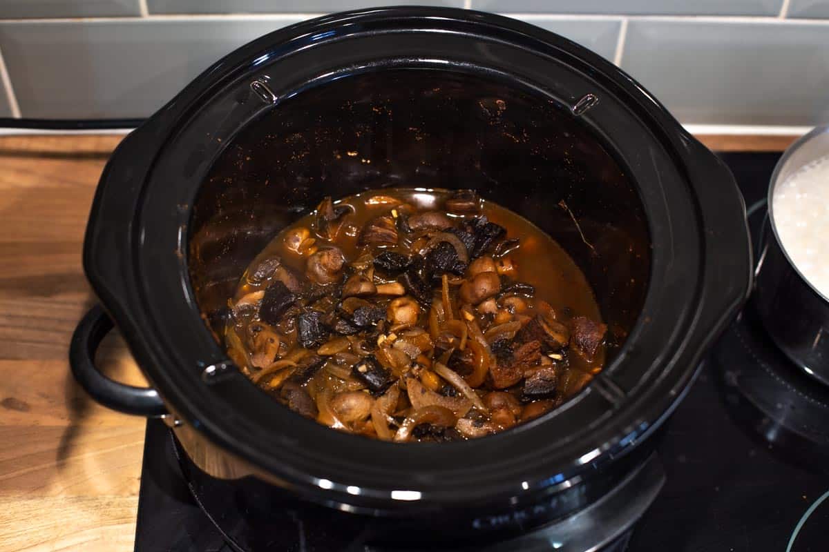 Mushrooms and onions cooked in a slow cooker.