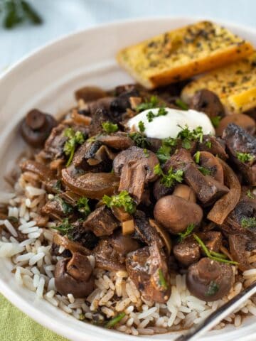 Mushroom stroganoff in a bowl with rice and parsley.