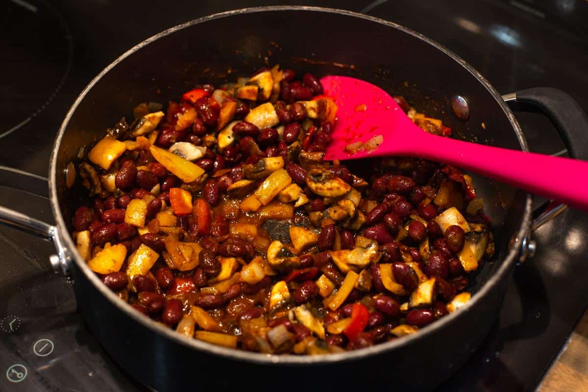 Vegetables and kidney beans cooking in a pan.