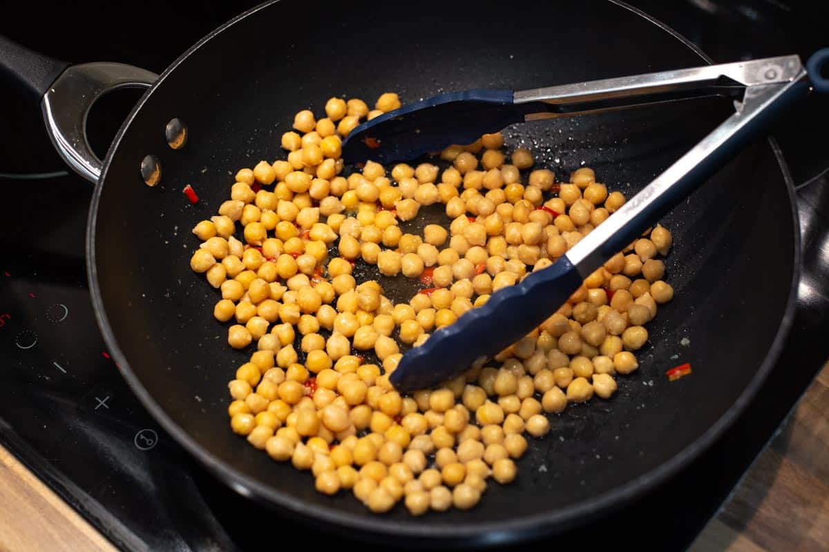 Chickpeas cooking in a wok.