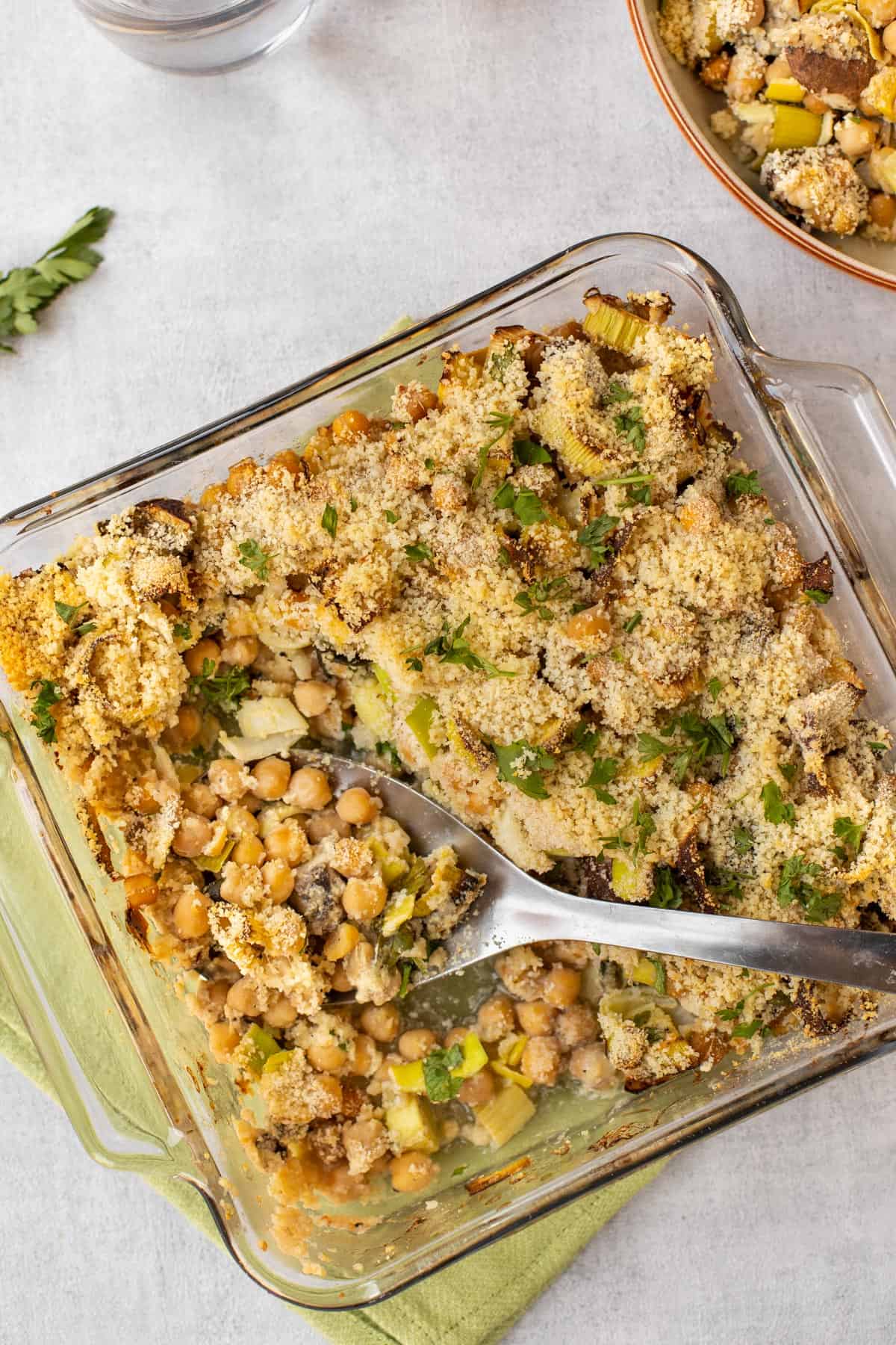 Lemony chickpea casserole in a baking dish with a scoop removed.