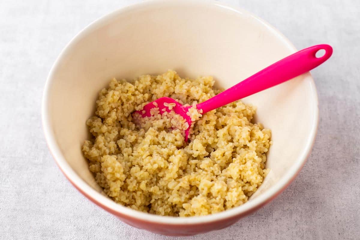 Cooked bulgur wheat in a mixing bowl.