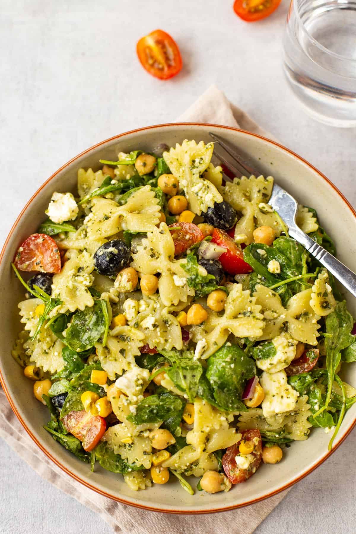 A portion of chickpea pasta salad with olives and feta in a bowl.