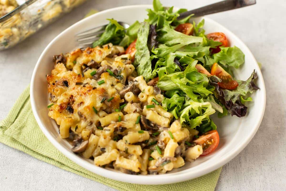 Garlic mushroom mac and cheese in a bowl with salad.
