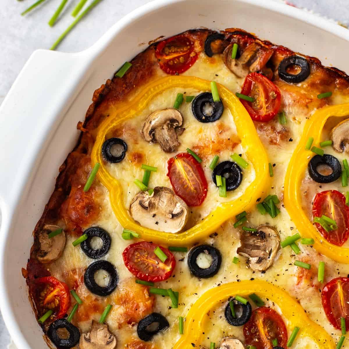 Pizza baked gnocchi topped with peppers, mushrooms and black olives.