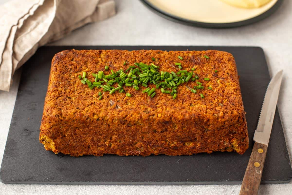 Vegan lentil loaf served on a black slate board.