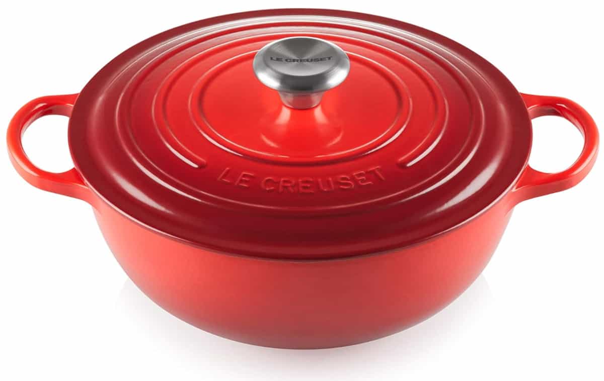 A red Le Creuset casserole dish on a white background.