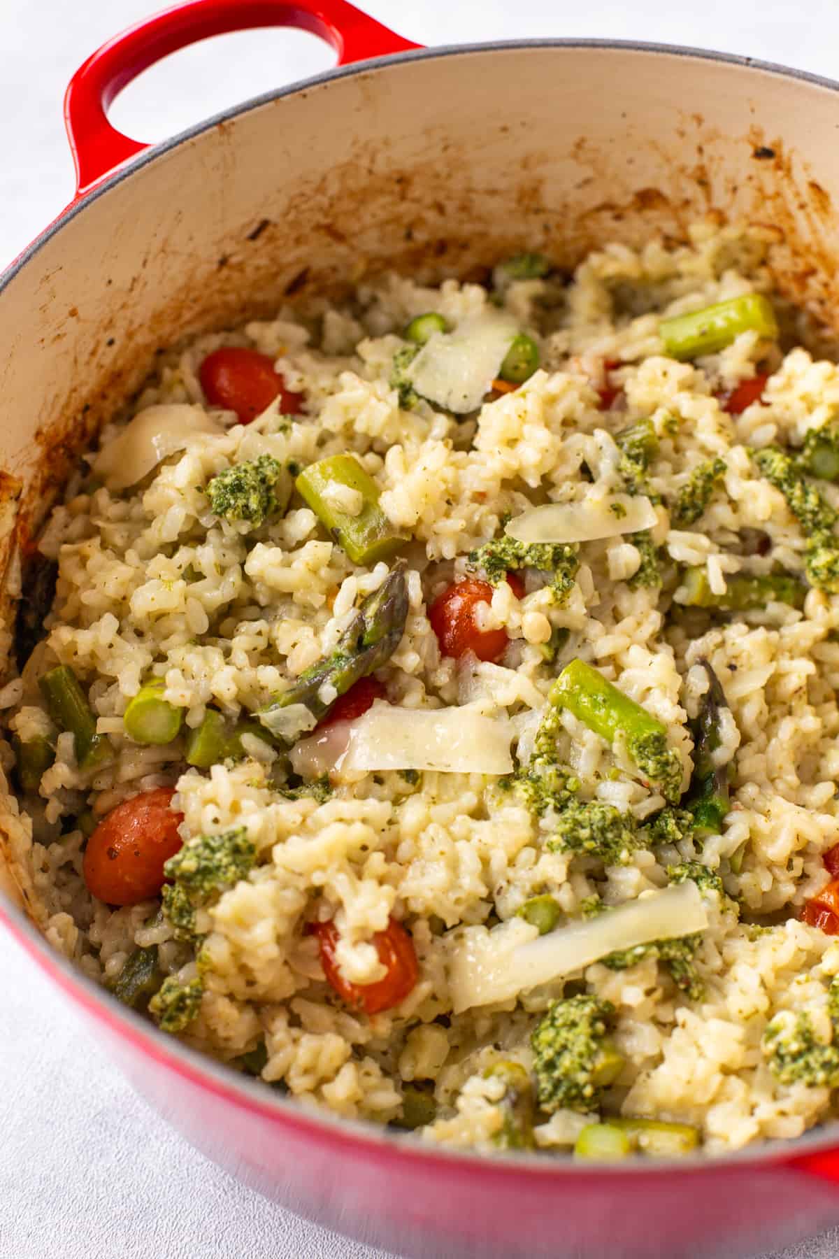 A panful of baked risotto with asparagus and tomatoes.