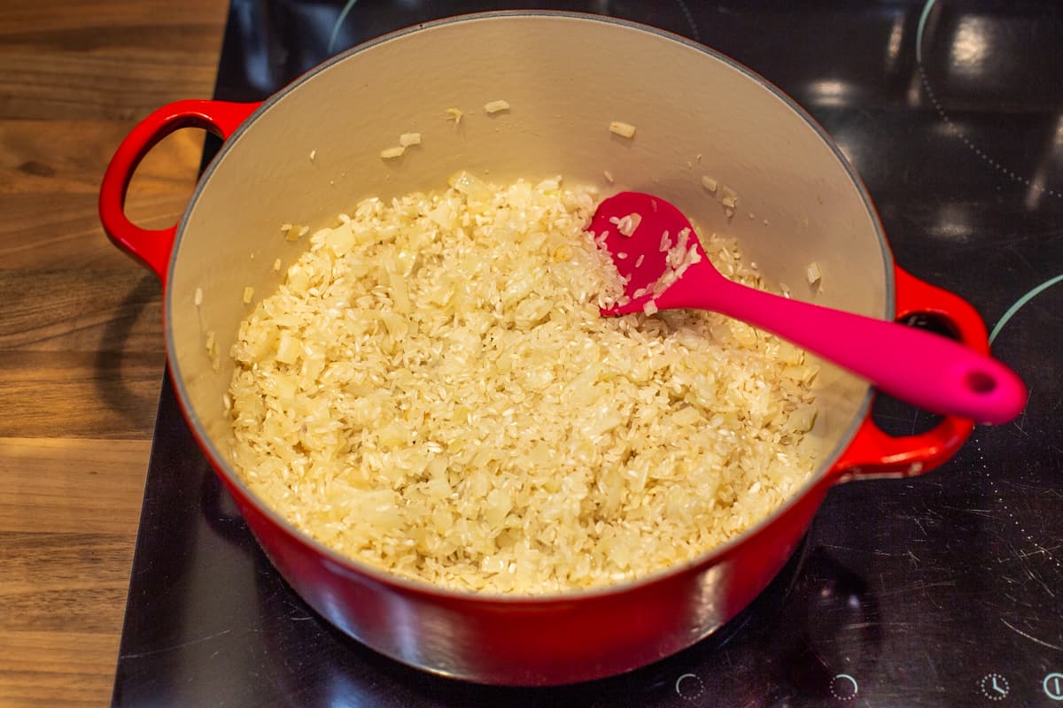 Risotto rice frying in oil with onion.