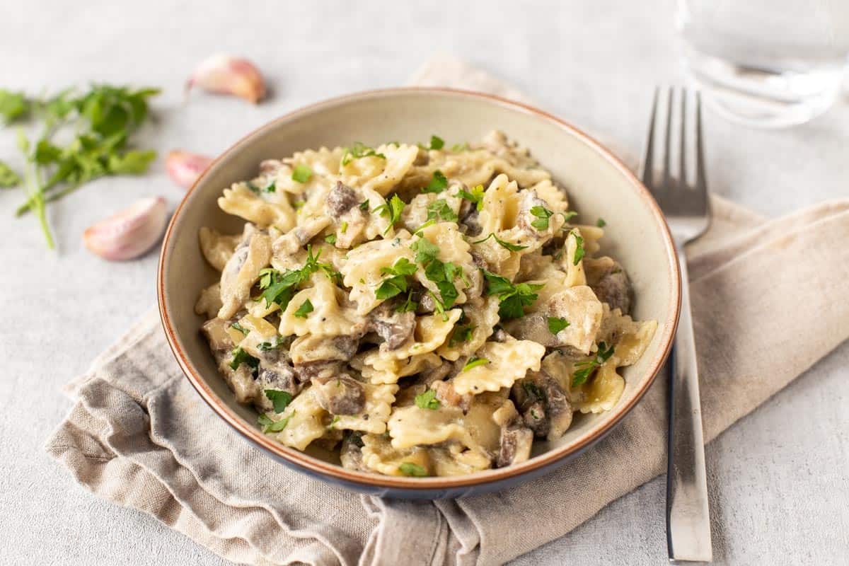 A portion of creamy mushroom pasta topped with parsley.
